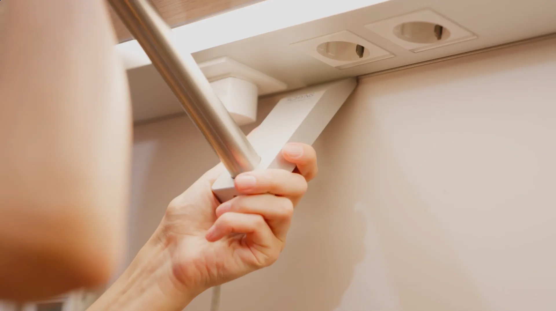 Close-up of a hand clicking an IV pole holder into a supply unit slot