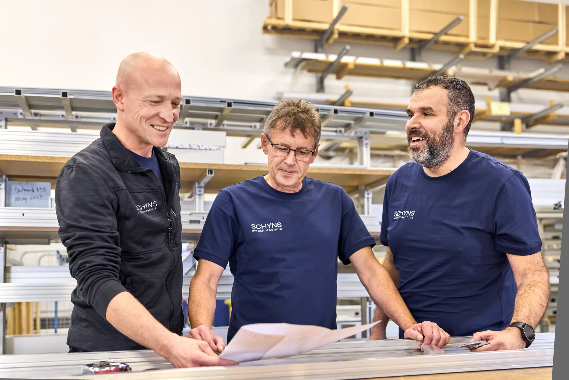 Drei Mitarbeiter besprechen gemeinsam einen Plan in der Fertigung