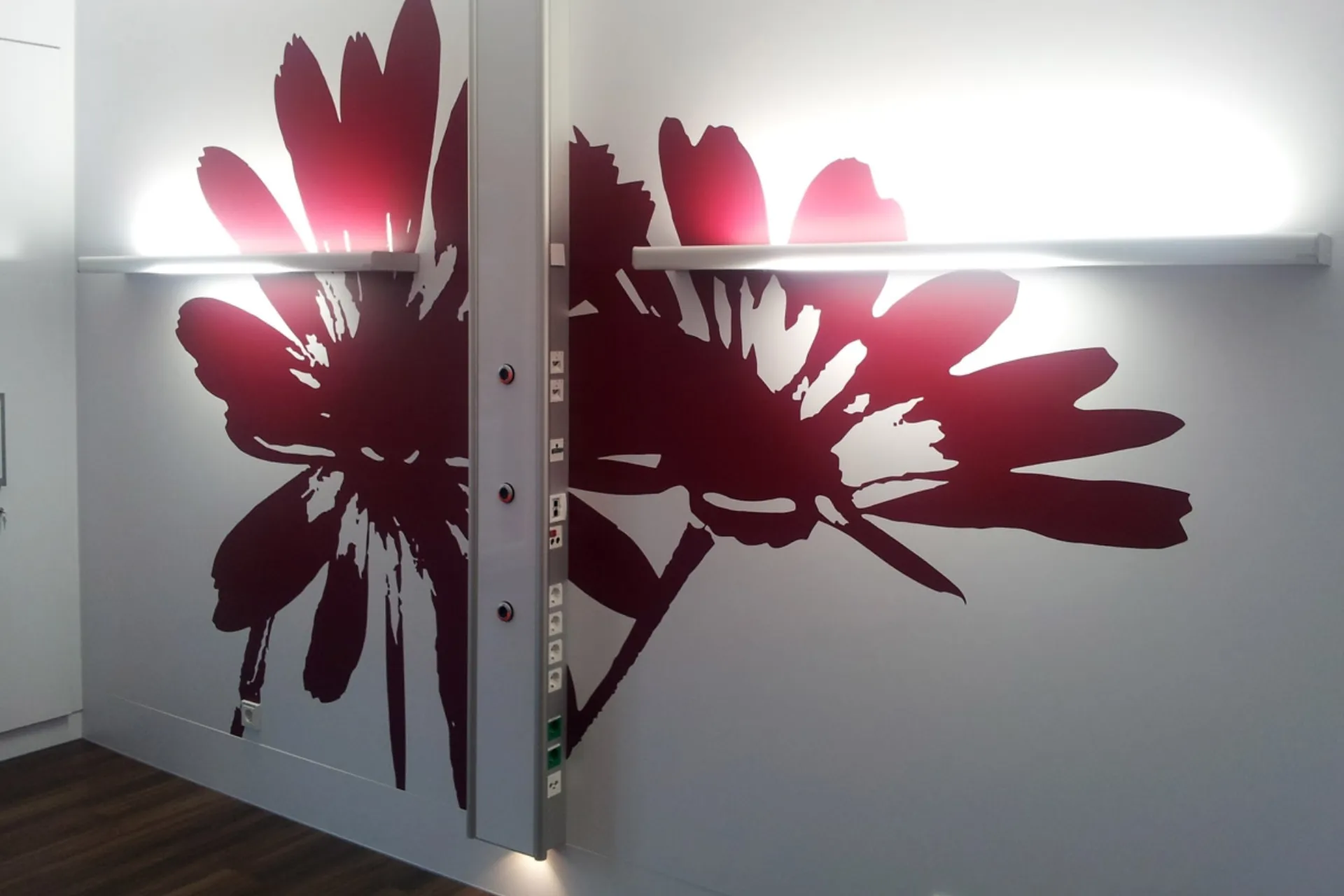 Large-scale dark-red floral patterns on a light wall with two horizontal light strips dividing the wall in the middle