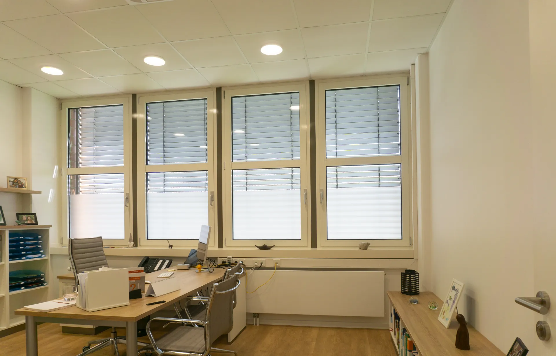 Treatment room with ceiling luminaires and a large window front.