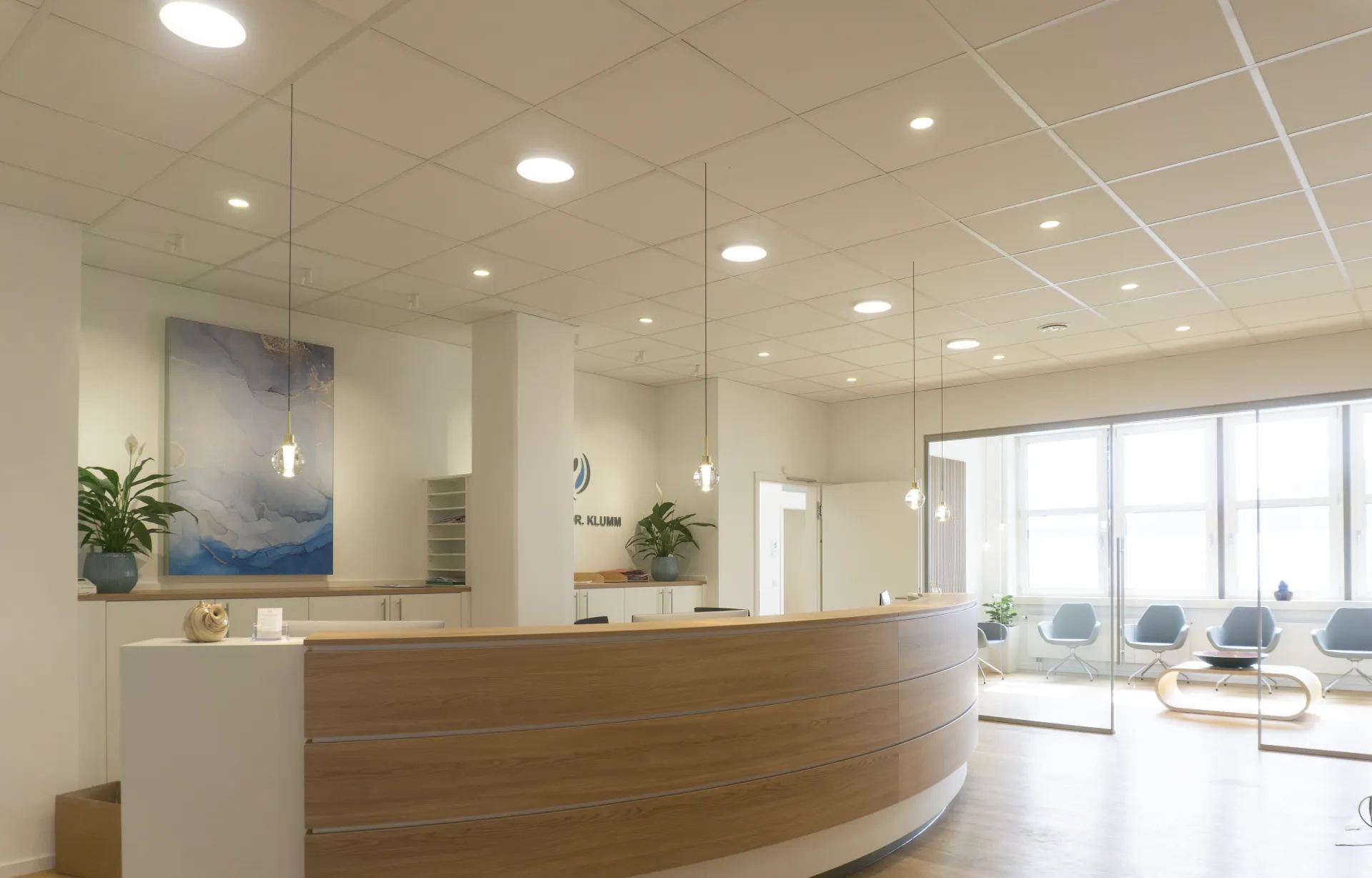 Entrance area of a practice, illuminated with the Alaska spherical pendant luminaire, Stram downlight and Buddy downlight.