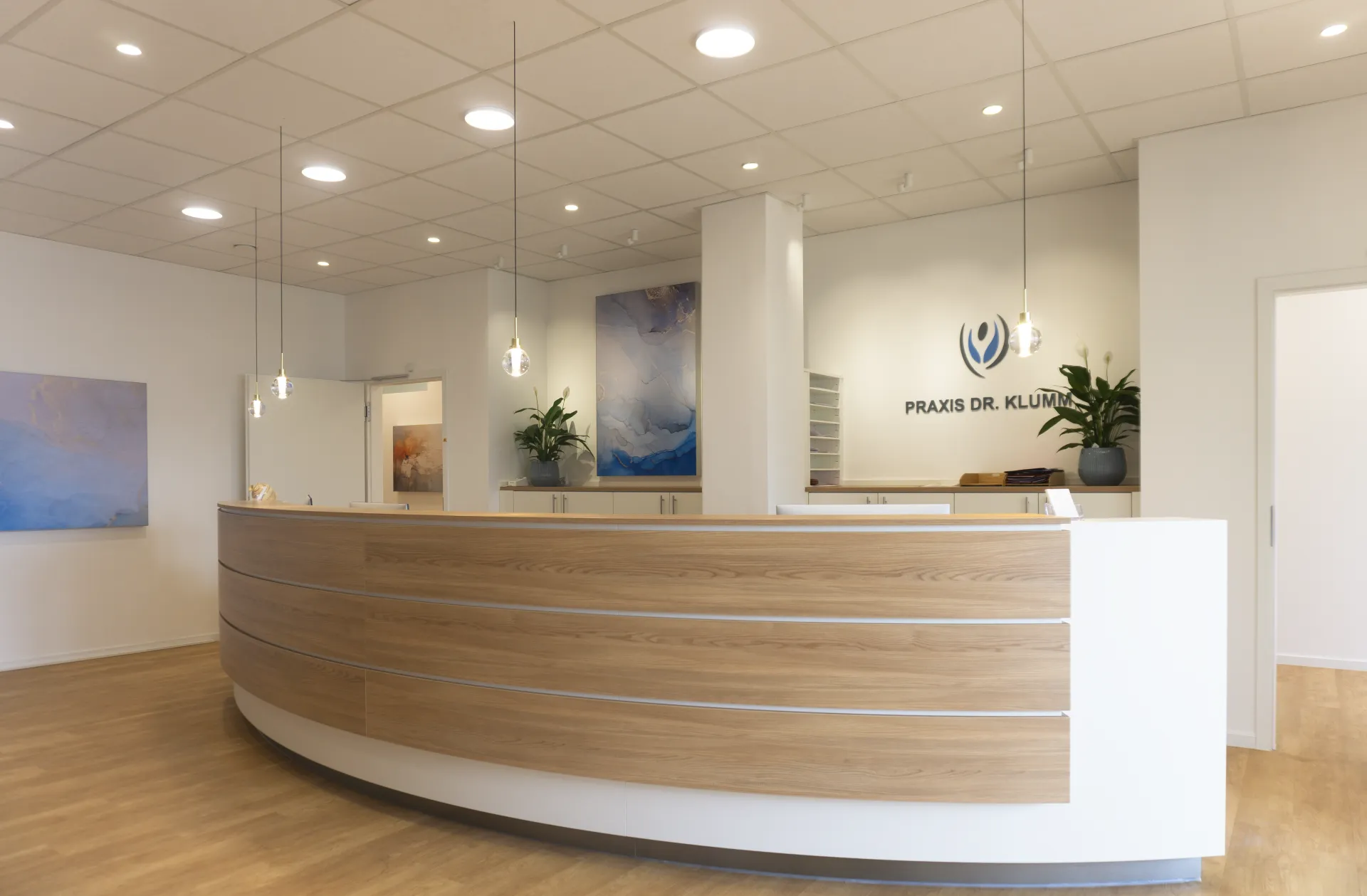 Entrance area of a practice, illuminated with the Alaska spherical pendant luminaire, Stram downlight and Buddy downlight.