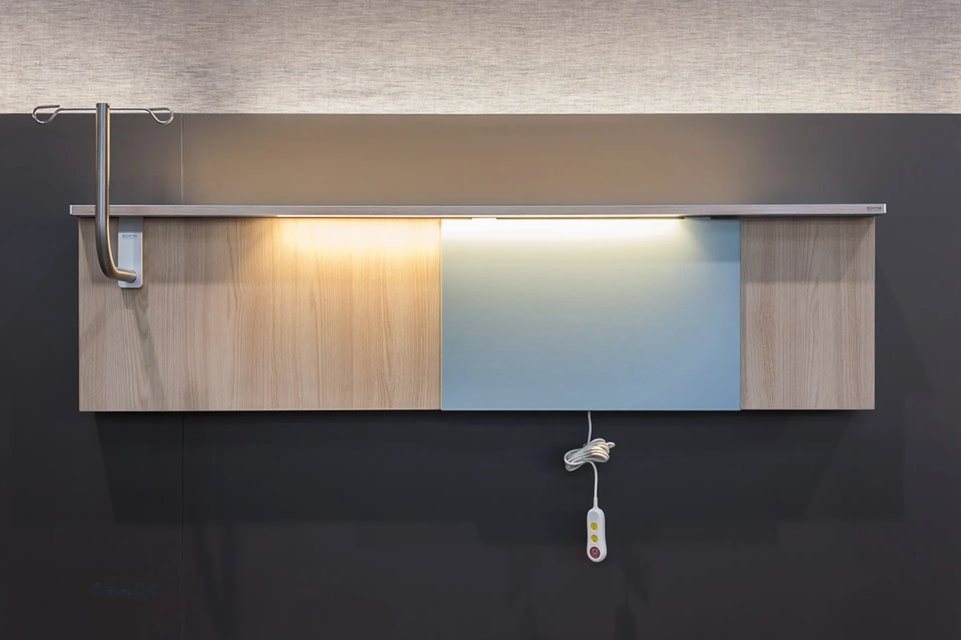 Wall-mounted medical installation with wood cladding, integrated light and a hanging control unit with cable