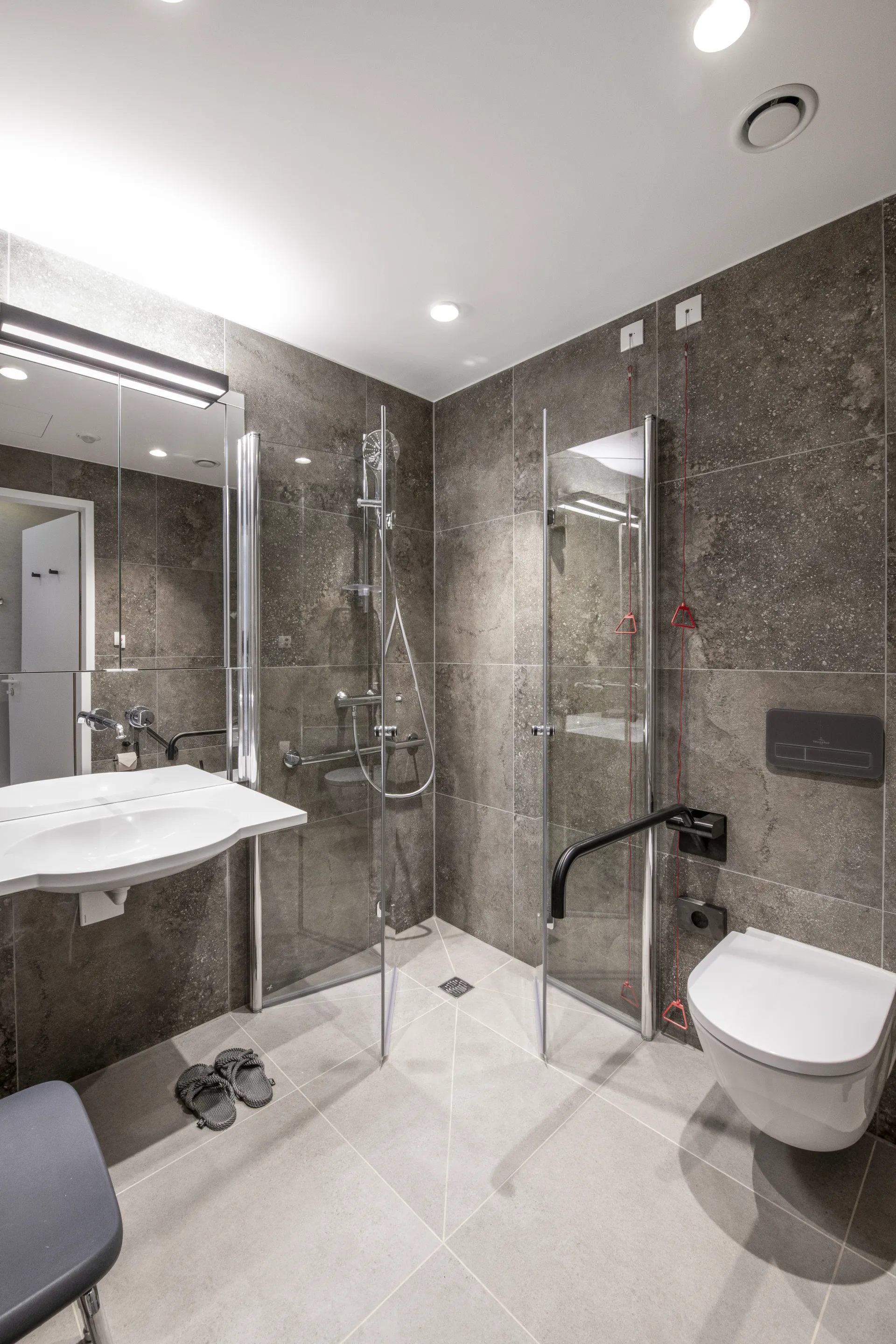 A modern bathroom with recessed spotlights in the ceiling.